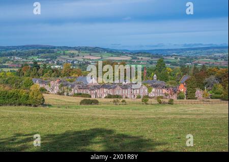 Ein landschaftlicher Blick vom Straßenrand in der Nähe des Naturschutzgebiets Pwll y Wrach, mit dem alten verlassenen Krankenhaus im Vordergrund. Stockfoto