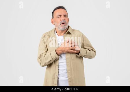 Ein älterer Mann hat Brustschmerzen im Hintergrund Stockfoto