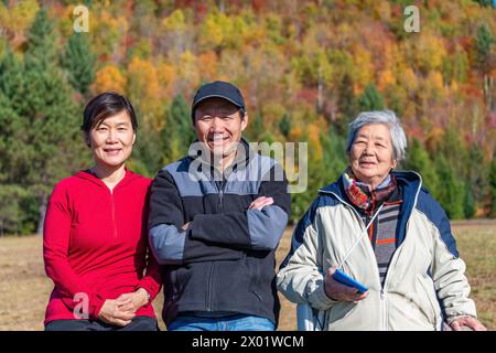 Seniorin und Familie posieren für Fotos in einem Park mit Herbstfarben im Hintergrund. Mont Tremblant. Québec. Kanada. Stockfoto