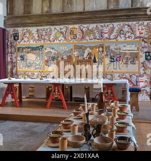 Banketttische, die alle für ein Festmahl in der Großen Halle im Tretower Court and Castle, Tretower, Powys, Wales, Großbritannien, aufgestellt wurden. Stockfoto