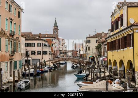 Chioggia, Veneto, Italien, 30. März 2024 : Chioggia in der Lagune von Venedig mit schmalen Vena-Wasserkanal mit bunten Booten zwischen alten Gebäuden Stockfoto