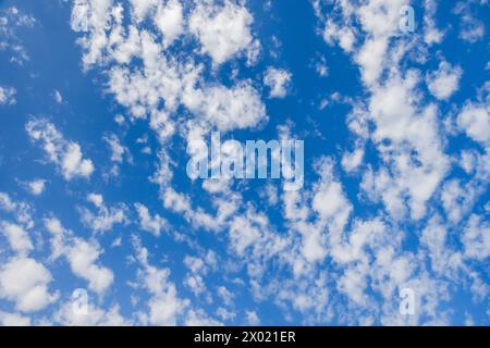 Blauer Himmel mit Schicht weißer Altocumulus-Wolken an einem sonnigen Tag, natürliche Hintergrundfotostruktur Stockfoto