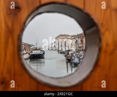 Chioggia, Veneto, Italien, 30. März 2024 : Chioggia in der Lagune von Venedig mit schmalen Vena-Wasserkanal mit bunten Booten zwischen alten Gebäuden Stockfoto