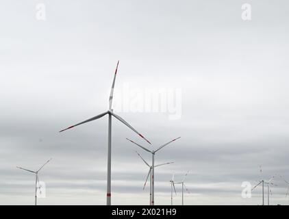 09. April 2024, Baden-Württemberg, Ilshofen: Windturbinen wenden sich bei starkem Wind und bewölktem Himmel zur Stromerzeugung an. Eine kalte Front aus der Nordsee beendet das Frühsommerwetter im Südwesten vorerst. Nach Angaben des Deutschen Wetterdienstes (DWD) wird es am Dienstag regnen, vor allem im Süden des Landes. Manchmal weht der Wind und kann in den Bergen sogar stürmisch werden. Am Nachmittag wird sogar auf dem Schwarzwaldgipfel Feldberg mit Schneeregen gerechnet. Nach der Abkühlung sollte es in Baden-Württemberg wieder viel Sonnenschein geben Stockfoto