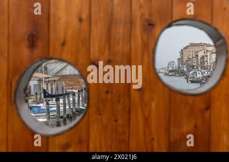 Chioggia, Veneto, Italien, 30. März 2024 : Chioggia in der Lagune von Venedig mit schmalen Vena-Wasserkanal mit bunten Booten zwischen alten Gebäuden Stockfoto