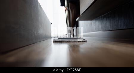 Afroamerikaner putzt den Boden, Butler wischt den Boden mit einem Mopp im Wohnzimmer Stockfoto