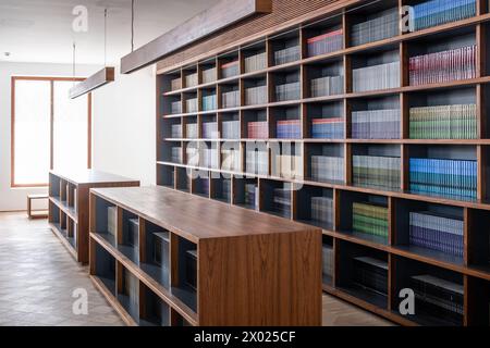 MUHARRAQ, BAHRAIN - 10. FEBRUAR 2018: Farbcodierte Bücher füllen die Bücherregale einer neuen, sauberen Bibliothek. Stockfoto