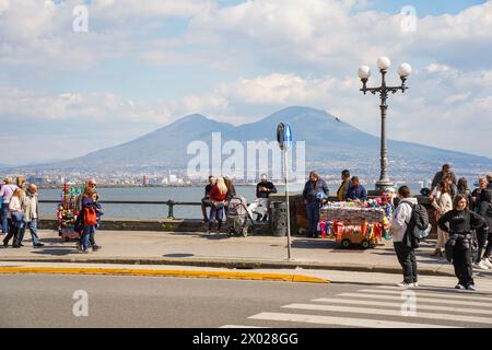 Leute spazieren an einem samstagnachmittag entlang der Uferpromenade, Via Partenope, Vesuv im Hintergrund, Neapel, Italien. Stockfoto