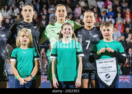 Christchurch, Neuseeland, 9. April 2024: Daisy Cleverley, Victoria Esson und Ali Riley (von links nach rechts) singen die neuseeländische Nationalhymne, begleitet von den Spieltagsmaskottchen vor dem Freundschaftsspiel zwischen Neuseeland und Thailand im Apollo Projects Stadium in Christchurch, Neuseeland. Quelle: James Foy / Alamy Live News Stockfoto