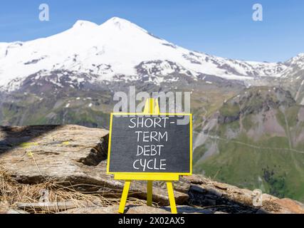 Symbol für den kurzfristigen Schuldenzyklus. Concept Words kurzfristiger Schuldenzyklus auf wunderschöner schwarzer Kreidetafel. Wunderschöner Berg Elbrus Hintergrund. Unternehmen Stockfoto