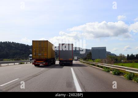 Überholer von Lkw auf einer dreispurigen Autobahn von hinten Stockfoto