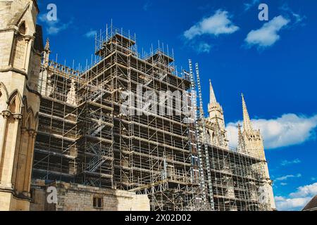 Die historische Kathedrale wird renoviert, mit komplizierten Gerüsten vor einem hellblauen Himmel mit Wolken. Architektonische Konservierungskonzepte in York Stockfoto