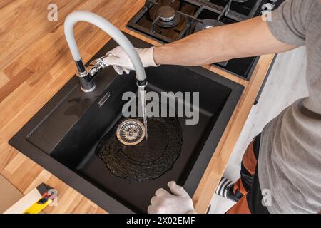 Kaukasischer Klempner Überprüft Die Wasserversorgung Der Küche. Prüfung Des Spülwasserhahns. Stockfoto