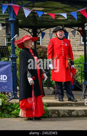 Männlicher Stadtschrei (bunte Schreieruniform, laute Stimme), der proklamiert, öffentlich verkündet und verkündet - Ilkley, West Yorkshire, England, Großbritannien. Stockfoto