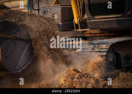Selektiver Fokus auf Metall-Eimer Zähne Bagger graben Boden. Baggerarbeiten durch Erdarbeiten auf der Baustelle. Raupenbagger graben auf dem Boden Stockfoto