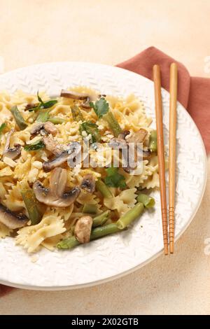 Vegetarische Pasta mit Pilzen, Petersilie, Bohnen und Käse auf orangefarbenen Tischen, Nahaufnahme Stockfoto
