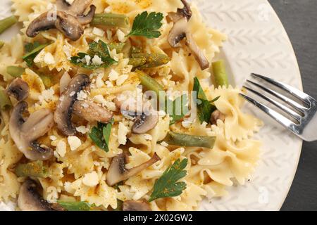 Vegetarische Pasta mit Pilzen, Petersilie, Bohnen und Käse auf weißem Teller, Nahaufnahme Stockfoto