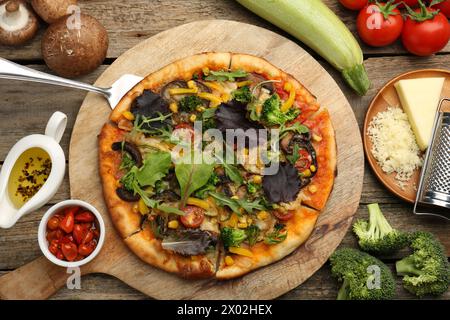 Köstliche vegetarische Pizza und Zutaten auf Holztisch, flach gelegen Stockfoto