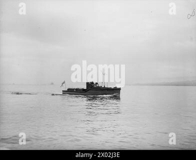 MOBILE DEMS-LEHRYACHT. 23. FEBRUAR 1942 AN BORD DER MY MELITA, GOUROCK BAY. DER MOTORSTART IST DER ERSTE LEHRSTART, DER FÜR DIE VERTEIDIGUNGSAUSRÜSTUNG VON HANDELSSCHIFFEN IM VEREINIGTEN KÖNIGREICH EINGESETZT WIRD. SIE FÄHRT TÄGLICH ZU DEN ANKERPLÄTZEN, UM DIE HANDELSSEEMÄNNER AUF DEM LAUFENDEN ZU HALTEN UND ÜBER DIE NEUESTEN VERBESSERUNGEN FÜR DIE VERTEIDIGUNG IHRER SCHIFFE ZU INFORMIEREN. - MEINE MELITA macht sich auf zu einem Arbeitstag unter den Handelsschiffen, die meine Melita vor Anker liegen Stockfoto