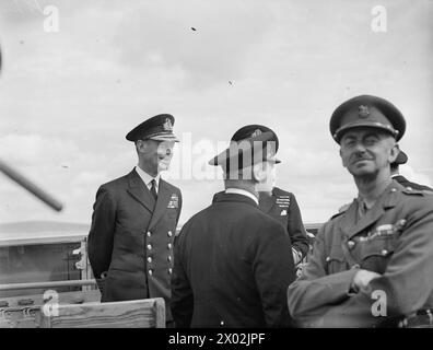 DER KÖNIG BESUCHT DIE HEIMATFLOTTE. 15. AUGUST 1943, SCAPA FLOW. DER KÖNIG BESUCHTE MÄNNER UND SCHIFFE DER HEIMATFLOTTE, ER GING AN BORD DES FLOTTENFÜHRERS HMS ONSLOW, DER IHN ZUM FLAGGSCHIFF HMS DUKE OF YORK BRACHTE. HIER TRAF DER KÖNIG AUF ADMIRAL SIR BRUCE A FRASER, KBE, CB, C-IN-C-FLOTTE. - Der König auf der Brücke der HMS PHOEBE in fröhlicher Stimmung Stockfoto