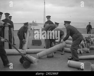 ROYAL MARINES AN BORD DER HMS VICTORIOUS. JANUAR BIS 5. FEBRUAR 1942 IN SCAPA, AUF SEE UND IN HVALFJORD ISLAND. - Royal Marines Munitionsparty, die 4,5' Granaten aus einem Feuerzeug abwirft Stockfoto