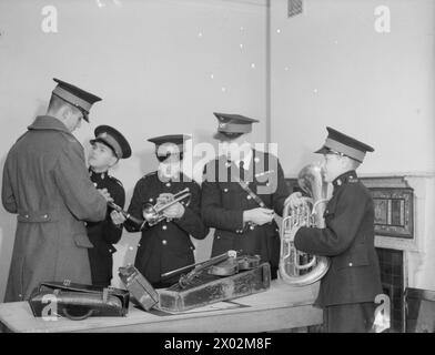 DER 14-JÄHRIGE JUNGE IST MITGLIED DER ROYAL MARINES BAND. 8. JANUAR 1942, SCARBOROUGH. DER 14-JÄHRIGE REGINALD DAVID WARDEN TRAT DER ROYAL MARINE SCHOOL OF MUSIC IN SCARBOROUGH BEI UND WURDE IHR JÜNGSTES MITGLIED. DIE SCHULE VERSORGT ALLE MUSIKER UND MARINEBANDS MIT HM-SCHIFFEN UND LANDBASEN. - Mit anderen jungen Rekruten wählt er das Instrument, das er spielen will. Reginald, rechts, hat sich für das Euphonium entschieden Stockfoto