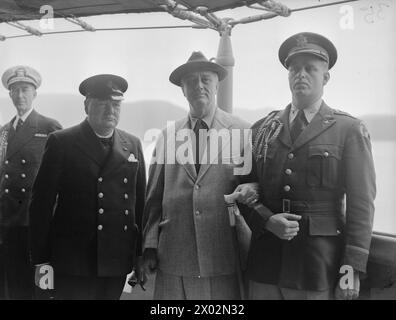 Am 10. August 1941 trafen sich Premierminister Winston Churchill und Präsident Franklin D. Roosevelt während der Atlantic Conference an Bord der HMS Prince of Wales, wobei Captain Elliot Roosevelt und ein Berater des Präsidenten anwesend waren. Stockfoto