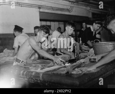 EIN TAG IM LEBEN EINES „JUNGEN“, WILLIAM LAWRENCE, EIN 17-JÄHRIGER LAD AN BORD DES JUNGEN-TRAININGSSCHIFFS HMS IMPRÄGNIERBAR. 7. SEPTEMBER 1940, AN BORD VON HMS IMPRÄGNIERBAR. - Er muss seine Kleidung waschen und hier ist das Scheuerbrett Stockfoto