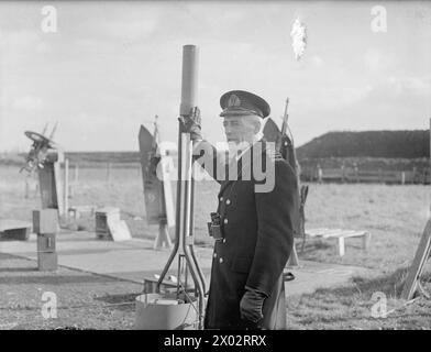 DEMS-SCHÜTZEN HALTEN PACE MIT DEN NEUESTEN KRIEGSWAFFEN. 11. UND 12. NOVEMBER 1943, DEMS RANGES, CARDIFF. DAS DEMS-TRAININGSZENTRUM, IN DEM DIE MÄNNER, DIE FEINDLICHE SEE- UND LUFTANGRIFFE AUF ALLIIERTE HANDELSSCHIFFE ABWEHREN, AUFFRISCHUNGSKURSE ABSOLVIEREN, UM PACE MIT IHREN NEUEN VERTEIDIGUNGSWAFFEN ZU VERSORGEN. - Commander H Wadsworth, RD, RNR, verantwortlich für das DEMS-Trainingszentrum, hält die DEMS-Männer über den Einsatz von Verteidigungswaffen Stockfoto