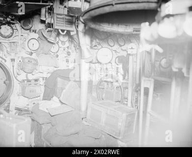 AN BORD DER KAPITULIERTEN U 532. 18. MAI 1945, GLADSTONE DOCK, LIVERPOOL. AN BORD DER U 532 GAB SICH DIE BLOCKADE DES DEUTSCHEN U-BOOTS AUF DEM WEG VON JAPAN MIT EINER LADUNG AUS TIN, CHININ, WOLFRAM UND GUMMI IM ATLANTIK AUF. - Im Kontrollraum von U 532. Beachten Sie das schwarze Katzenmaskottchen neben der Maschine Stockfoto