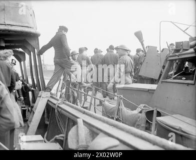 DAS ERSTE U-BOOT ERGIBT SICH. 10. MAI 1945, WEYMOUTH BAY. DAS DEUTSCHE U-BOOT U 249 MIT FÜNF OFFIZIEREN UND 47 MANNSCHAFTEN AN BORD ERGAB SICH DEM KOMMANDANTEN H J WEIR, RN. SIE WAR DIE ERSTE, DIE GROSSBRITANNIEN ERREICHTE UND KAM UNTER DER ESKORTE ZWEIER BRITISCHER SLOOPS MIT DEM WEISSEN FÄHNRICH. - Die deutsche U-Boot-Besatzung geht an Land Stockfoto