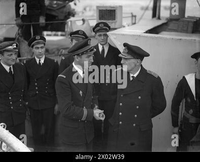 IM KAMPF GEGEN DIE FRANZÖSISCHE CORVETTE VERSENKT 2 U-BOOTE. AM 14. MÄRZ 1943 VERSENKTE GREENOCK, DIE FRANZÖSISCHE CORVETTE ACONIT, ZWEI U-BOOTE VON GUNFIRE UND RAMMTE, WÄHREND SIE AM 10. MÄRZ 1943 EINEN ATLANTIKKONVOI DURCH EIN U-BOOT-PACK BEGLEITETE. DAS ZWEITE U-BOOT HATTE GERADE DEN BRITISCHEN ZERSTÖRER HMS HARVESTER TORPEDIERT. DIE ACONIT FUHR ZU EINEM BRITISCHEN HAFEN MIT ÜBERLEBENDEN DES ERNTEERS UND EINEM KAUFMANN UND GEFANGENEN AUS DEN BEIDEN U-BOOTEN. - Vizeadmiral Truppe, Flaggenoffizier in Glasgow, gratulierte Leutnant de Vaissea Jean Levasseur, 32 Jahre alter kämpfender Franzose, Kapitän der FFS ACONIT an Bord der Co Stockfoto