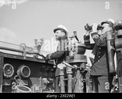 Zwischen dem 11. Und 15. März 1944 wird in Neapel Leutnant Nigel R H Rodney, Kommandant des Zerstörers der Jagdklasse HMS Brecon, mit First Lieutenant A M Cole-Hamilton und dem Hundemaskottchen Salvo auf der Brücke gezeigt. Stockfoto