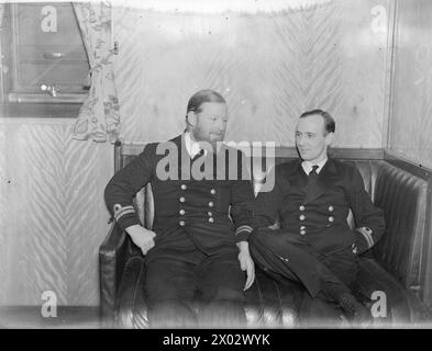 DAS U-BOOT THUNDERBOLT, EHEMALS HMS THETIS, KEHRTE NACH EINER PATROUILLE NACH HARBOUR ZURÜCK. 1940. - Captain von The THUNDERBOLT, Lieut Cecil Ernest Crouch (rechts), plaudert mit Lieut J Stevens, dem ersten Leutnant auf dem Depot-Schiff Stockfoto