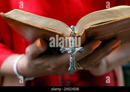 Frau, die die Heilige Bibel liest und Rosenkranz mit Jesus am Kreuz, Kambodscha, Indochina, Südostasien, Asien Stockfoto