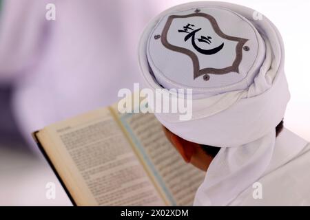 Muslimischer Mann, der einen arabischen Heiligen Koran liest, Jamiul Azhar Moschee, Vietnam, Indochina, Südostasien, Asien Stockfoto