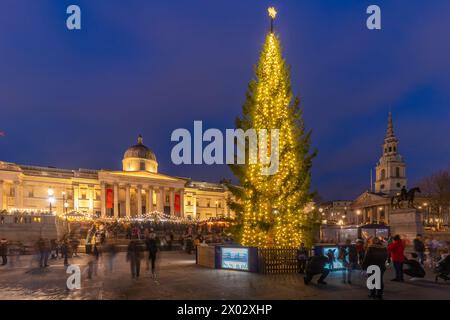 Blick auf den Weihnachtsmarkt und den Weihnachtsbaum vor der National Gallery am Trafalgar Square in der Abenddämmerung, Westminster, London, England, Großbritannien Stockfoto