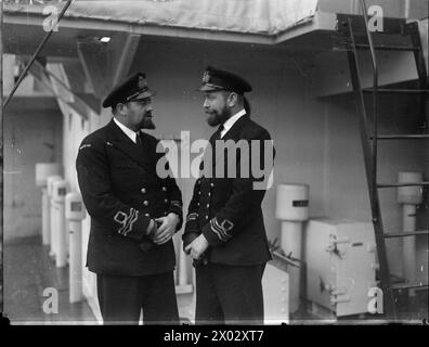 DER HOHE KOMMISSAR NEUSEELANDS BESUCHT CORVETTE. 24. FEBRUAR 1944, GREENOCK. DER HOHE KOMMISSAR VON NEUSEELAND, HERR JORDAN, BESUCHTE DIE NEUE BLUMENKLASSE CORVETTE, HMNZS ARABIS. - Leutnant Commander J H Seelye, RNZNVR, von Dunedin, Befehlshaber der ARABIS (rechts), zusammen mit Leutnant Commander J A Rhind, RNZNVR, von Lyttelton, Neuseeland Stockfoto