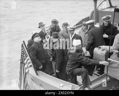 MR. CHURCHILLS SEEREISE IN DIE USA - ERSTE BILDER. MAI 1943, AN BORD DER SS QUEEN MARY AUF DEM WEG IN DIE USA. HERR CHURCHILL WURDE VON HOCHRANGIGEN BEAMTEN UND MINISTERN BEGLEITET. - Der Premierminister mit einem breiten Lächeln im Gesicht schaut auf die jubelnden Massen, während er aussteigt. Zu seiner Linken gehören Harry Hopkins und Admiral Adolphus Andrews von der US Navy Stockfoto