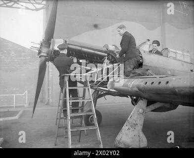 MÄNNER FÜR DIE FLOTTENLUFTWAFFE FÜR DIE ZUKUNFT. 15. UND 16. DEZEMBER 1943, ROYAL AIR TRAINING ESTABLISHMENT, NEWCASTLE-UNDER-LYME. JUNGE BRITEN, DIE SICH AUF EINEN WICHTIGEN JOB VORBEREITEN, JUNGEN AB 15 JAHREN, DIE FÜR DIE FLOTTENFLUGWAFFE TRAINIEREN. - Luftfahrtschuller, die einen modernen Flugzeugmotor (Merlin Three) in den Rahmen einer Maschine einbauen Stockfoto