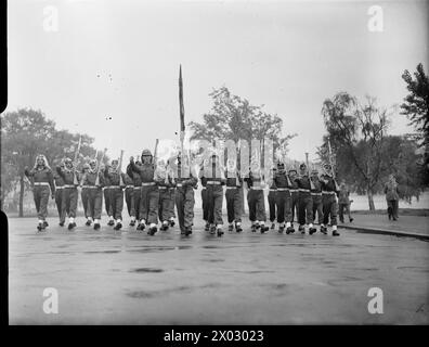 VICTORY MARCHERS CAMP IN LONDON: UNTERKUNFT IN KENSINGTON GARDENS, LONDON, ENGLAND, Großbritannien, 1946 - Männer der Arabischen Legion nehmen an einer Probe im Hyde Park, London, Teil, um die SIEGESPARADE vorzubereiten. Alle haben Gewehre. Der Fahnenträger an der Vorderseite der Formation wird von zwei weiteren Soldaten flankiert, die Gewehre tragen. Sie marschieren auf die Kamera zu Stockfoto