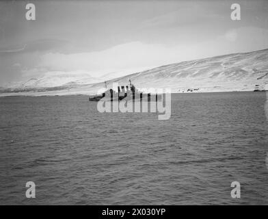 AN BORD DER HMS SIEGREICH. 23. BIS 28. JANUAR 1942 AN BORD DES FLUGZEUGTRÄGERS IN HVALFJORD, ISLAND. HMS VICTORIOUS UND ANDERE SCHIFFE DER FLOTTE PATROUILLIEREN IM NORDATLANTIK AUF DER SUCHE NACH DEM DEUTSCHEN SCHLACHTSCHIFF TIRPITZ. - Der Kreuzer HMS CUMBERLAND kommt in Hvalfjord vor der Patrouille Royal Navy, HMS Cumberland, Fregatte, (1986) Stockfoto