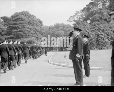 DER FÜNFTE SEE INSPIZIERT MARINE-LUFTFAHRTAUSBILDER. 22. JUNI 1945: ROYAL MARINEFLUGSTRAINESTATION IN NEWCASTLE-UNDER-LYME. DER FÜNFTE SEA LORD, KONTERADMIRAL T H TROUBRIDGE, CB, DSO UND BAR, FÜHRTE EINE AUSUFERNDE INSPEKTION VON MARINEFLUGZEUGEN DURCH. - Konteradmiral Troubridge, der den Gruß am vormarsch feiert Stockfoto