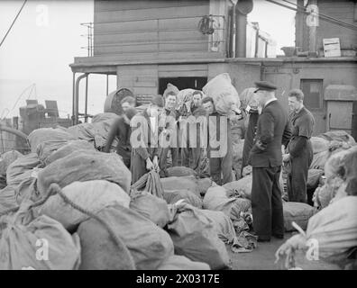 Am 18. Dezember 1942 sortierte die HMS Dunluce Castle am Ankerplatz der Home Fleet Weihnachtspost an Deck für die Verteilung an Schiffe und das Festland. Stockfoto
