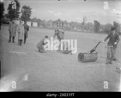 CRICKET-SPIEL: BERICHTERSTATTUNG ÜBER EIN SPIEL ZWISCHEN KENTON UND ALEXANDRA PARK, KENTON, MIDDLESEX, ENGLAND, GROSSBRITANNIEN, 1945: die Groundsmen markieren die Falte auf dem Kenton Cricket Ground vor dem Spiel gegen Alexandra Park Stockfoto