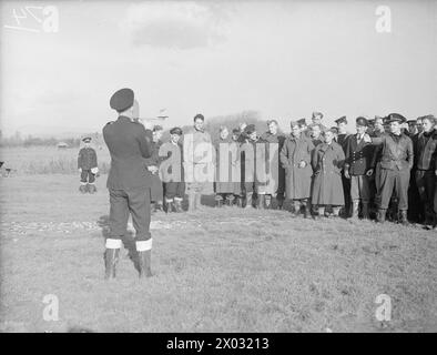 DEMS-SCHÜTZEN HALTEN PACE MIT DEN NEUESTEN KRIEGSWAFFEN. 11. UND 12. NOVEMBER 1943, DEMS RANGES, CARDIFF. DAS DEMS-TRAININGSZENTRUM, IN DEM DIE MÄNNER, DIE FEINDLICHE SEE- UND LUFTANGRIFFE AUF ALLIIERTE HANDELSSCHIFFE ABWEHREN, AUFFRISCHUNGSKURSE ABSOLVIEREN, UM PACE MIT IHREN NEUEN VERTEIDIGUNGSWAFFEN ZU VERSORGEN. - Einem Offizier des amerikanischen Handelsdienstes wurde seine Fehler in AIM gezeigt, mit Hilfe eines tragbaren Ziellehrers Stockfoto