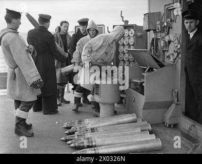 Am 25. April 1942 lädt eine Munitionspartei an Bord des Zerstörers HMS Pathfinder eine Waffe während der Action-Stationen. Stockfoto