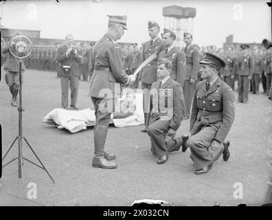 DIE POLNISCHE LUFTWAFFE IN GROSSBRITANNIEN, 1940-1947 – die neue polnische Luftwaffe wurde von Frauen und ihren Familien in Wilno (Wilno) in Polen, damals unter der sowjetischen Besatzung, eingeführt und von japanischen Diplomaten nach Schweden geschmuggelt, von wo sie schließlich im März 1941 Großbritannien erreichte. General Władysław Sikorski, Oberbefehlshaber der polnischen Streitkräfte, erteilt den Sergeant-Piloten während der neuen Standardpräsentationszeremonie der polnischen Luftwaffe am 16. Juli 1941 bei der RAF Swinderby Kommissionen. Beachten Sie zivile und offizielle Militärfotografen bei der Arbeit. Der Flieger auf den Bahren im Hintergras Stockfoto