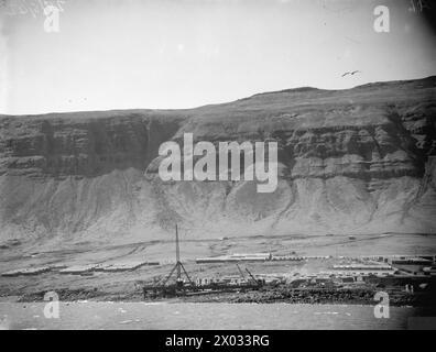 BRITISCHE UND US-AMERIKANISCHE FLUGZEUGE UND KRIEGSSCHIFFE DECKEN DEN RUSSISCHEN KONVOI AB. 29. MAI BIS 3. JUNI 1942 AN BORD DER HMS SIEGREICH AUF SEE UND IN HVALFJORD, ISLAND. - Ein Panoramablick auf das Südufer des Hvalfjord mit den Hütten und dem Pier von Hvitanes Stockfoto