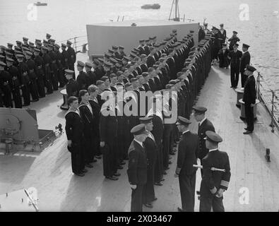 DER KÖNIG BESUCHT DIE HEIMATFLOTTE. 15. AUGUST 1943, SCAPA FLOW. DER KÖNIG BESUCHTE MÄNNER UND SCHIFFE DER HEIMATFLOTTE, ER GING AN BORD DES FLOTTENFÜHRERS HMS ONSLOW, DER IHN ZUM FLAGGSCHIFF HMS DUKE OF YORK BRACHTE. HIER TRAF DER KÖNIG AUF ADMIRAL SIR BRUCE A FRASER, KBE, CB, C-IN-C-FLOTTE. - Der König inspiziert die Divisionen während seines Besuchs bei HMS BELFAST Stockfoto